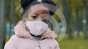 African American small girl ethnic baby pupil schoolgirl ill sick daughter child kid in medical face protective mask