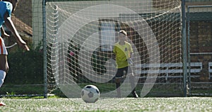 African American soccer kid in blue scoring in a sunny day