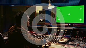 African american sound designer looks at greenscreen to record and edit tunes