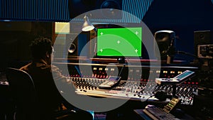 African american sound engineer working in control room with mixing console