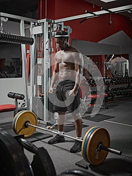 African american sports guy with muscular torso training with barbell in gym. Weightlifting, strength training