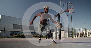African American sportsman dribbling ball on court