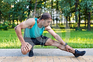 African american sportsman stretching in park