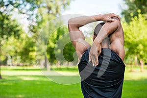 African american sportsman stretching in park