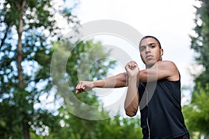 African american sportsman stretching in park