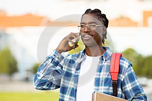 african american student guy talking on cell phone in park