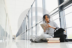 African american student with notebook in corridor in university