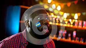 African american supporter with argentinian flag on cheek shocked with results