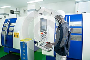 African American technician engineer operating CNC milling cutting machine in manufacturing workshop