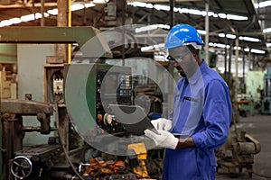 African american technician engineer use laptop to checking and control machines