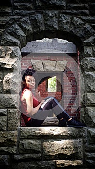 African American teen girl sitting alone in a window