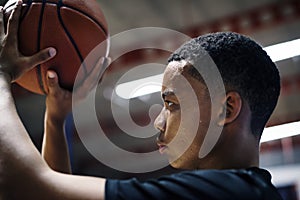 African American teenage boy concentrated on playing basketball