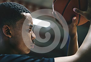 African American teenage boy concentrated on playing basketball