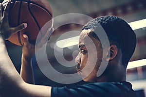 African American teenage boy concentrated on playing basketball