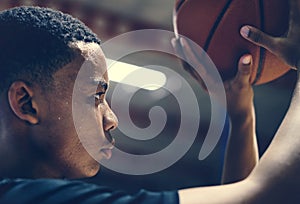 African American teenage boy concentrated on playing basketball