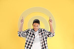 African-American teenage boy crossing his fingers on background