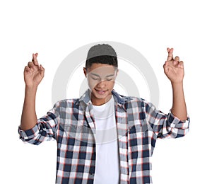 African-American teenage boy crossing his fingers on white