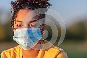 African American Teenager Girl Woman Wearing Coronavirus COVID-19 Face Mask photo