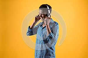 African American teenager in headphones listens to music.