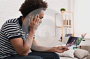 African-american teenager looking at photo of girlfriend