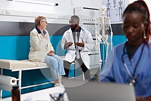 African american therapist doctor explaining sickness diagnosis to senior retired woman patient