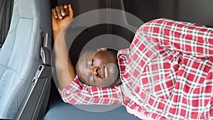 African american truck driver sleeping in his cabin after working long routes overtime