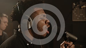 African American vocalist in headphones sings