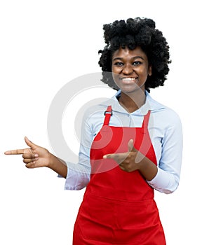 African american waitress with red apron pointing sideways