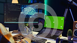 African american web developer using isolated mockup on pc and writing code