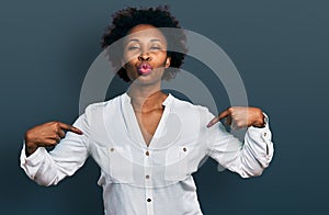 African american woman with afro hair pointing with fingers to herself looking at the camera blowing a kiss being lovely and sexy