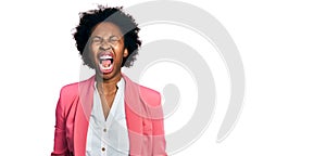 African american woman with afro hair wearing business jacket angry and mad screaming frustrated and furious, shouting with anger