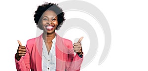 African american woman with afro hair wearing business jacket success sign doing positive gesture with hand, thumbs up smiling and