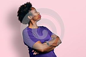 African american woman with afro hair wearing casual purple t shirt looking to the side with arms crossed convinced and confident