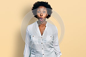 African american woman with afro hair wearing casual white t shirt afraid and shocked with surprise expression, fear and excited