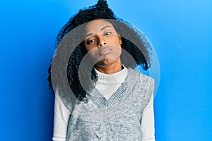 African american woman with afro hair wearing casual winter sweater looking sleepy and tired, exhausted for fatigue and hangover,