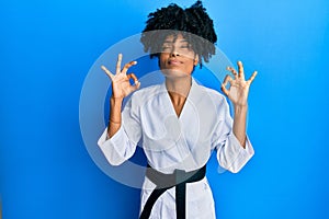 African american woman with afro hair wearing karate kimono and black belt relax and smiling with eyes closed doing meditation