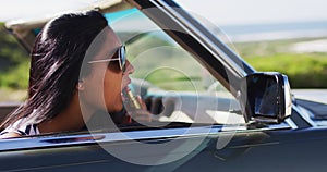African american woman applying lipstick while looking in the mirror of convertible car