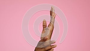 African American Woman Applying Moisturizer On Hands, Pink Background, Cropped