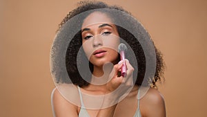 African American woman applying powder make-up natural beauty clean soft moisturized hydrated skin care treatment girl