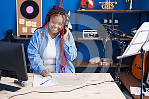 African american woman artist composing song at music studio