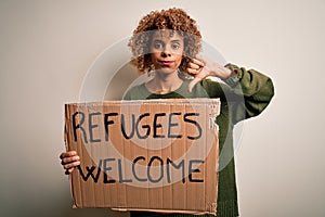 African american woman asking for immigration holding banner with wlecome refugees message with angry face, negative sign showing