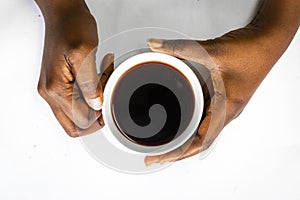 African American woman both hands holding a white cup of coffee. Black Female hands holding a hot cup of coffee with foam