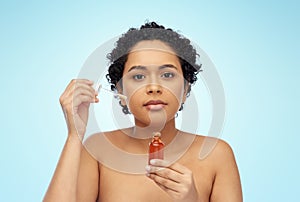 african american woman with bottle of serum