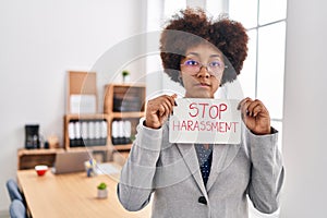 African american woman business worker holding stop harassment message banner at office