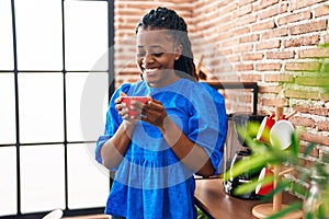 African american woman business worker smiling confident drinking coffee at home