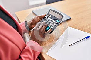 African american woman business worker using calculator at office