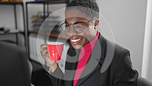 African american woman business worker using computer drinking coffee at office