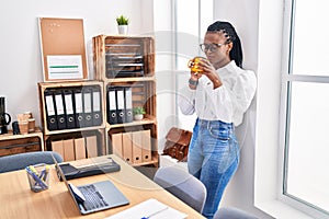 African american woman business worker using laptop drinking coffee at office