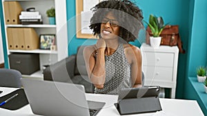 African american woman business worker using touchpad and laptop suffering for cervical pain at the office