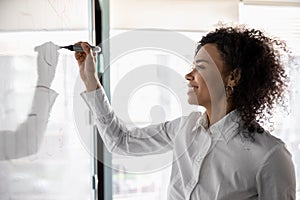 African American woman busy developing business strategy on board